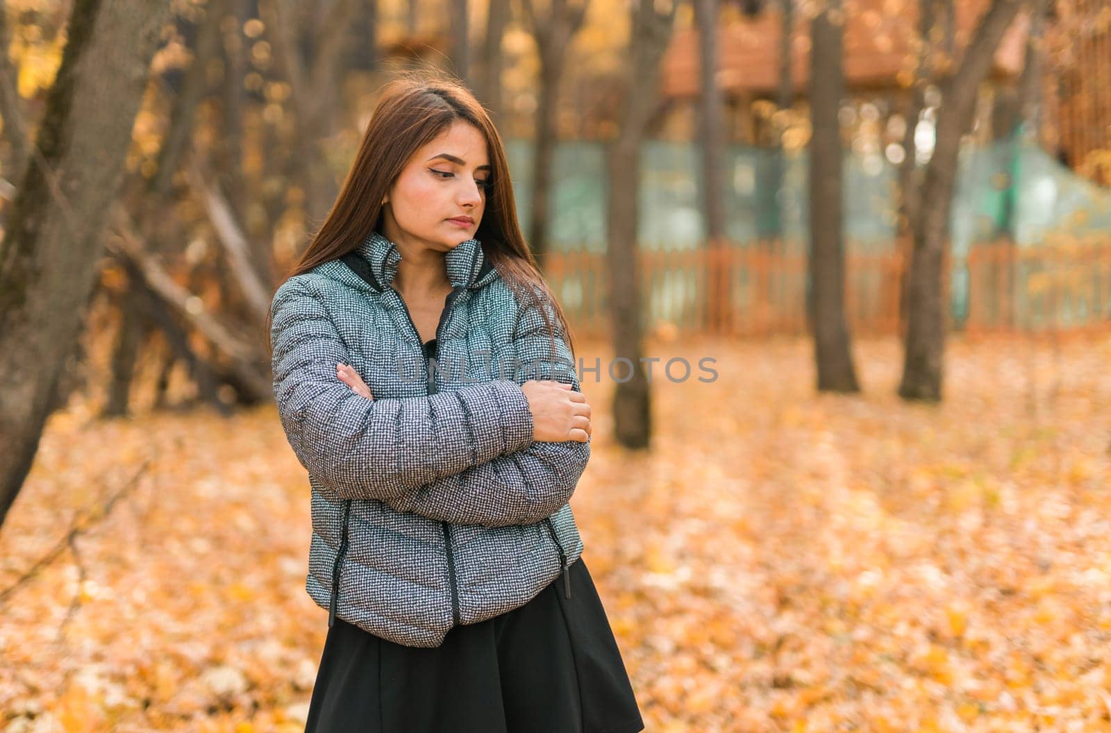 Close-up portrait of a young beautiful confident Indian Asian woman in fall outdoor. Happy and natural smiling female. Generation z and gen z youth