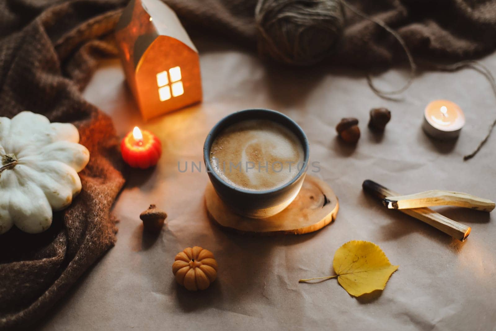 Autumn or winter cozy home interior with a cup, candles, plaid. Hygge home decor. by paralisart