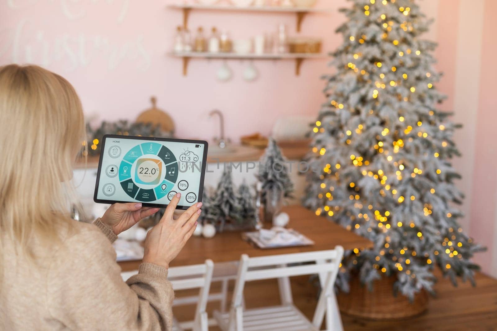 Modern home smart automation app on tablet display in woman hands at Christmas.