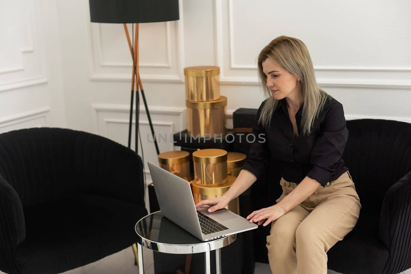 Young beautiful woman with long hair using laptop in room with Christmas tree. Portrait of carefree happy girl student in house in christmas.