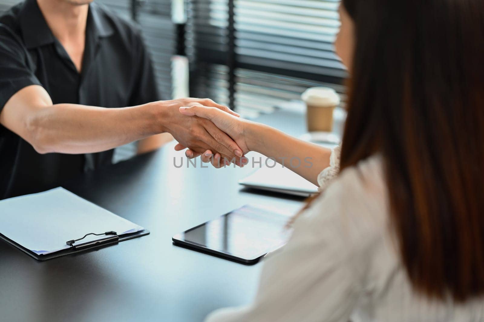 Cropped image of recruitment manager shaking hand with male candidate after an interview.