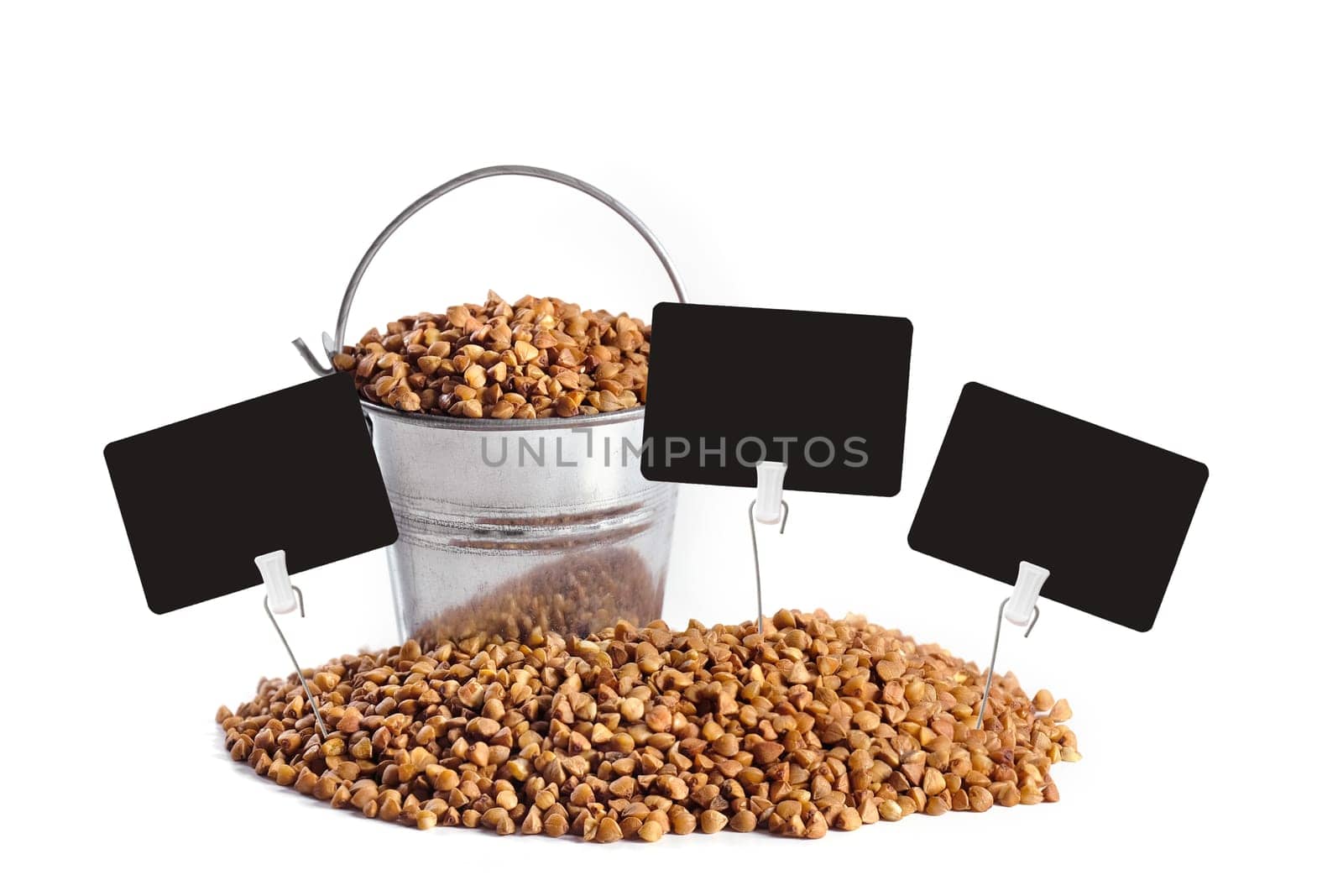 Metal bucket and buckwheat with empty price tags isolated on white background. Harvesting.