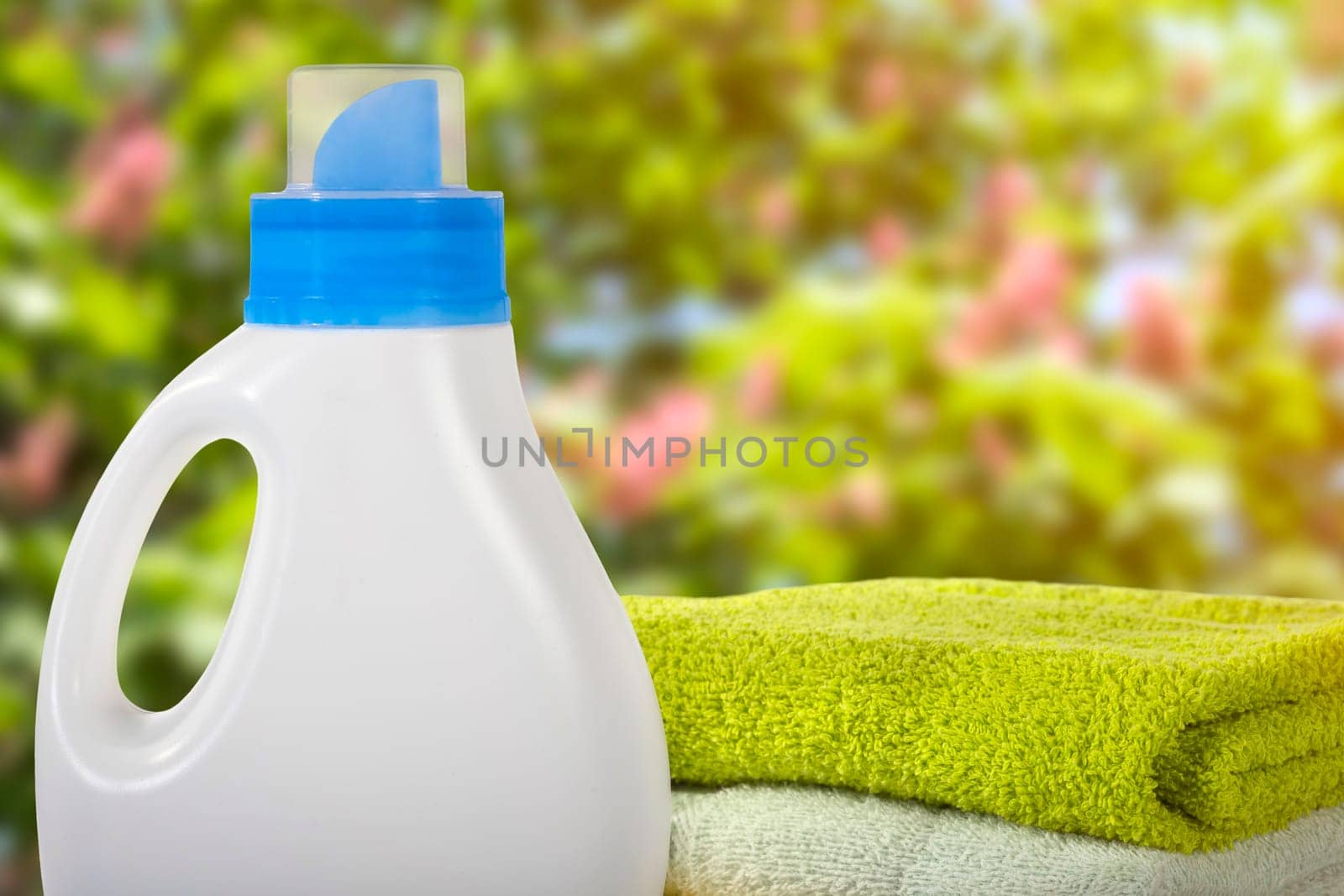 Plastic container for detergents and towels on a blurred garden background. Cleaning concept.