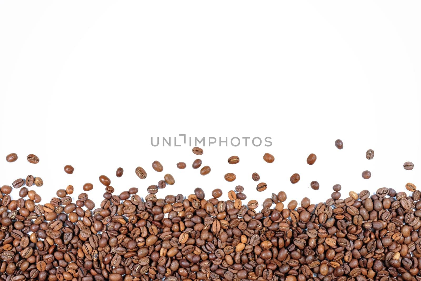 Roasted coffee beans isolated on a white background. Top view.