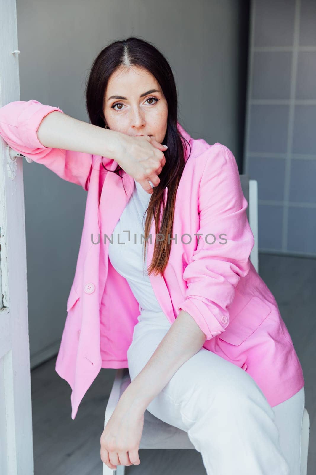 brunette woman in white suit and pink jacket