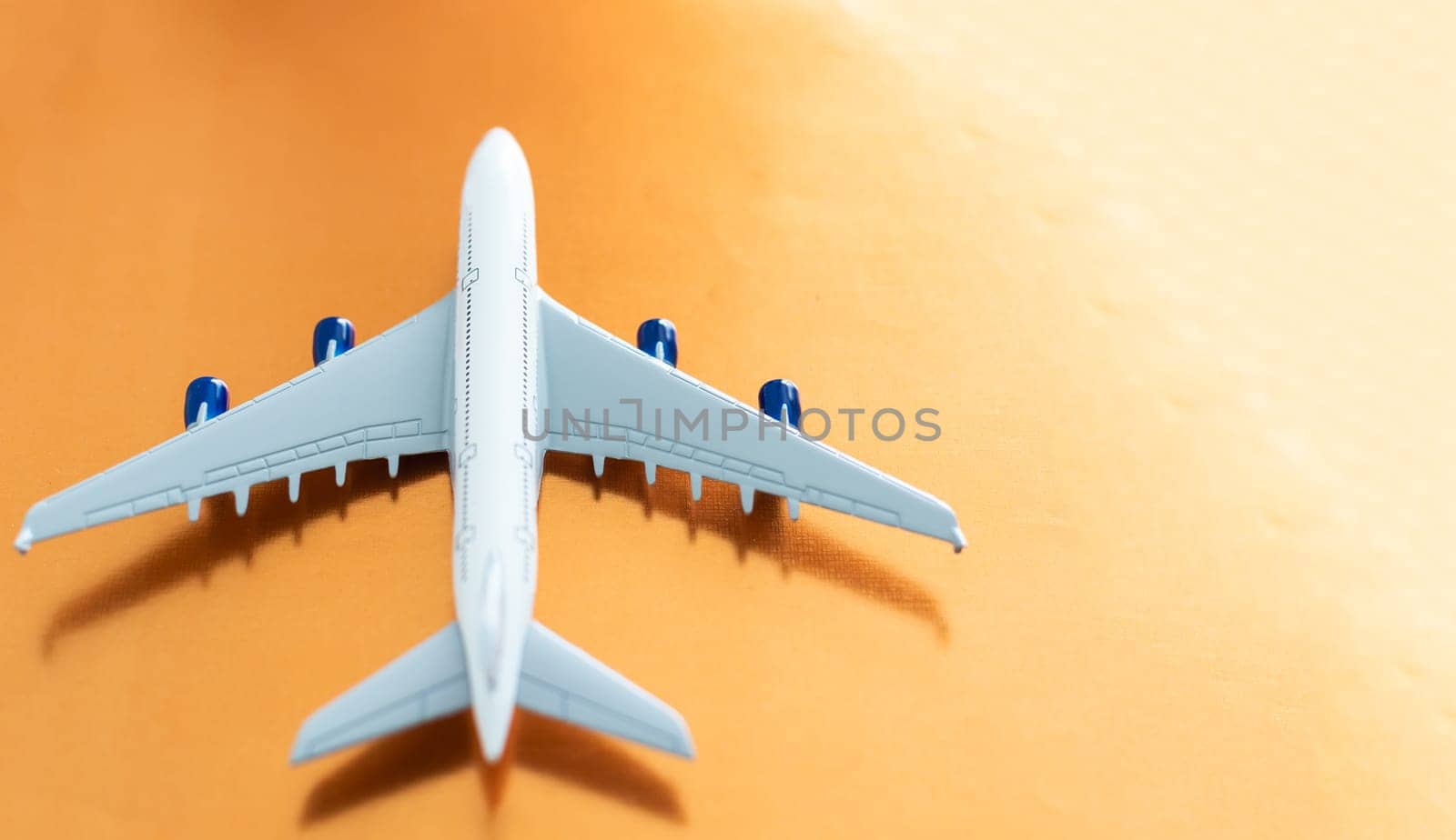 Airplane on orange background, flat lay, travel concept.