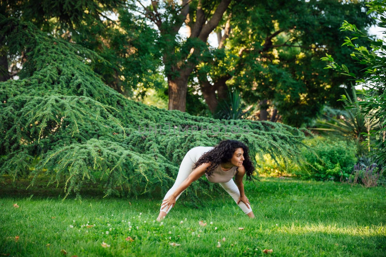 Young asian woman practicing yoga during workout in park