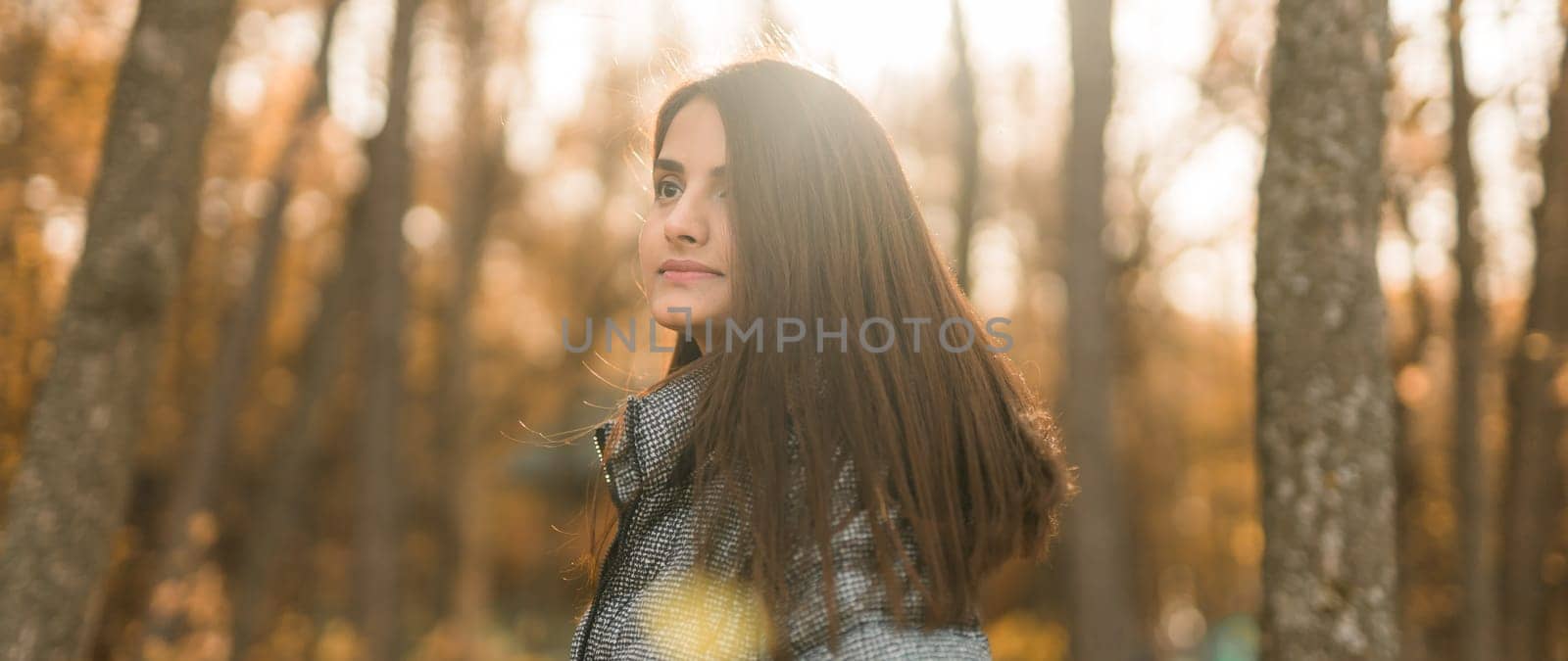 Banner beautiful indian woman generation z relaxing and feeling nature at autumn park in fall season copy space. Diversity and gen z youth by Satura86