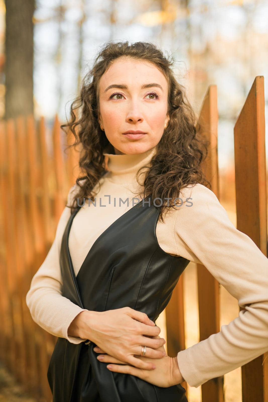 Autumn portrait of a beautiful happy curly woman in fall season. Millennial generation female. Natural beauty