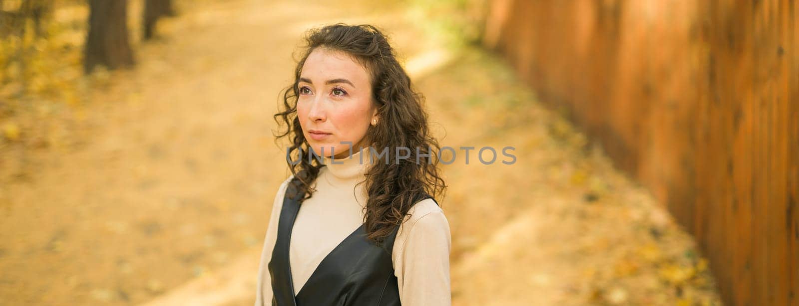 Banner autumn portrait of a beautiful happy curly woman in fall season copy space mockup. Millennial generation female. Natural beauty concept by Satura86
