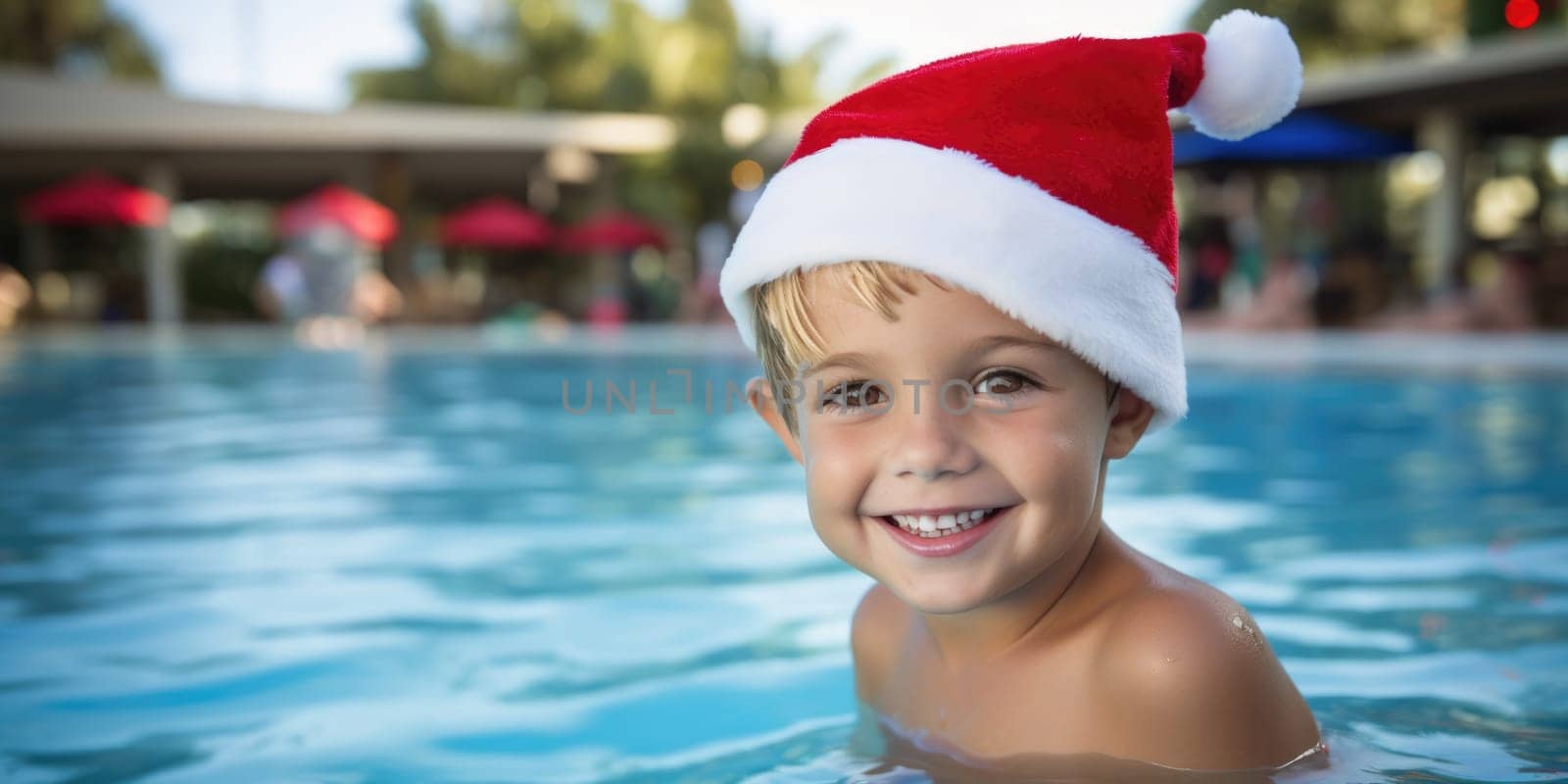 portrait of a happy boy in santa hat celebrating christmas in pool party. AI Generated by Desperada