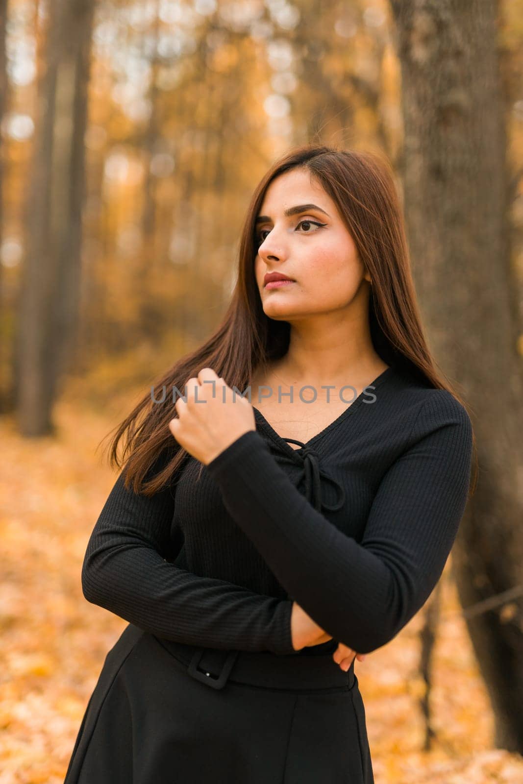 Close up portrait of pretty indian young woman enjoying warm autumn sunny day vacation outdoors. Generation z and gen z concept. Fall Season.