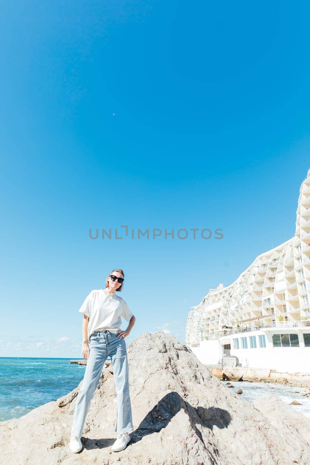 Beautiful slender woman walking on the beach near the seashore by Simakov