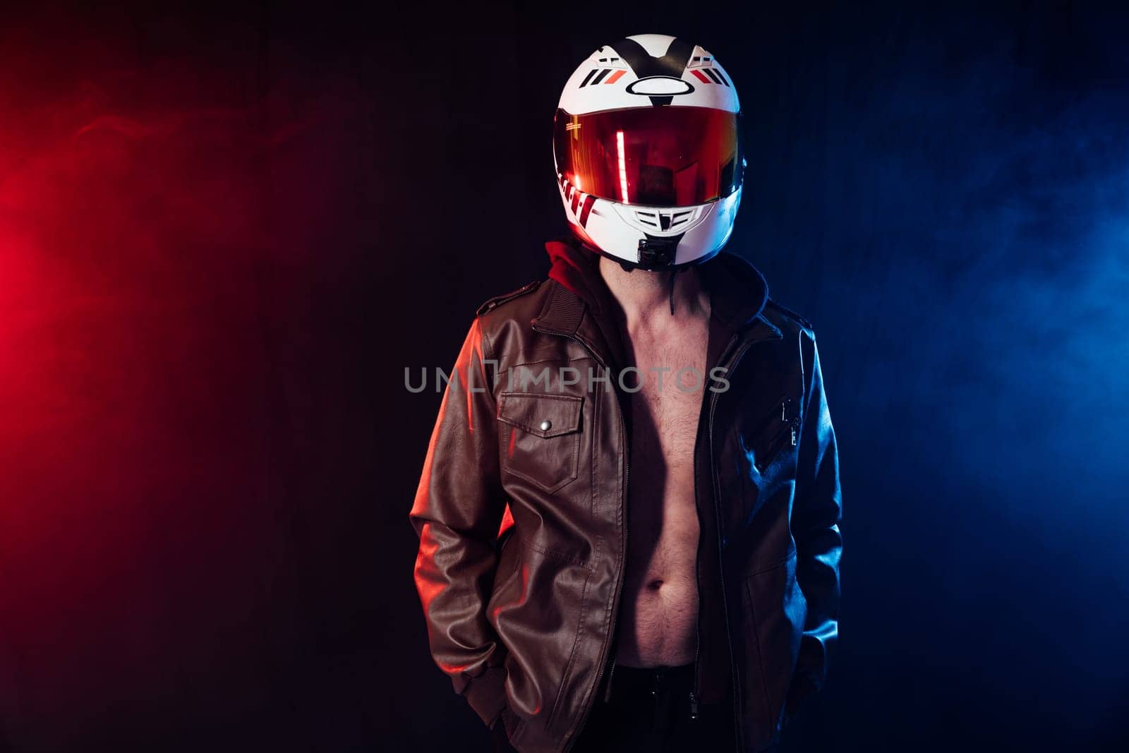 biker in motorcyclist helmet on dark