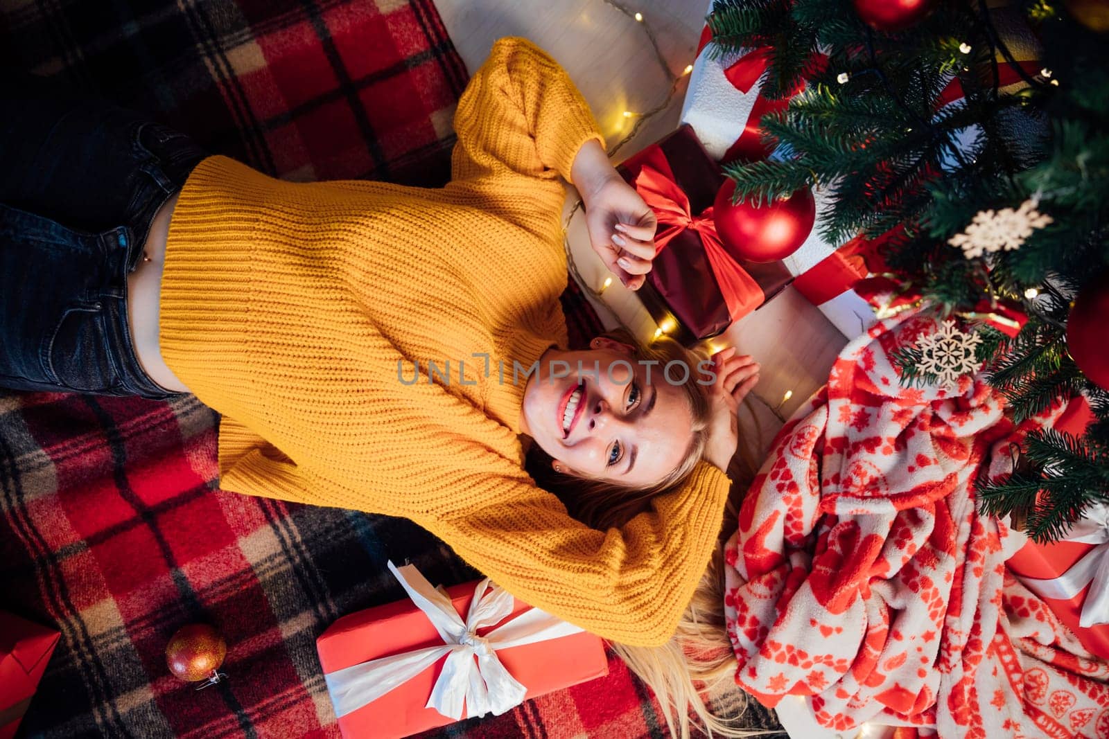 woman at christmas tree with gifts for new year