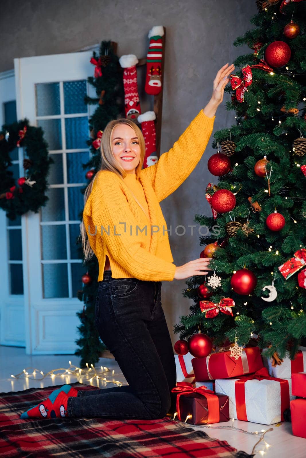 woman at christmas tree with gifts for new year