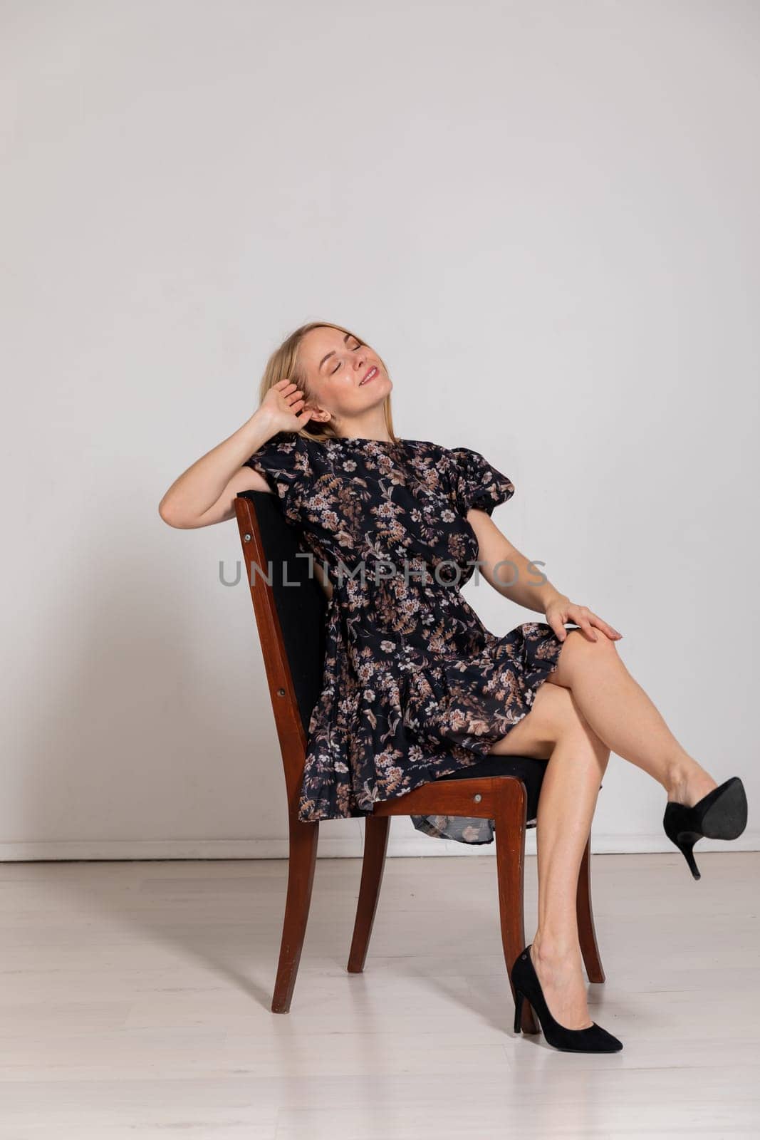 Portrait of a slender blonde woman in a dark summer dress