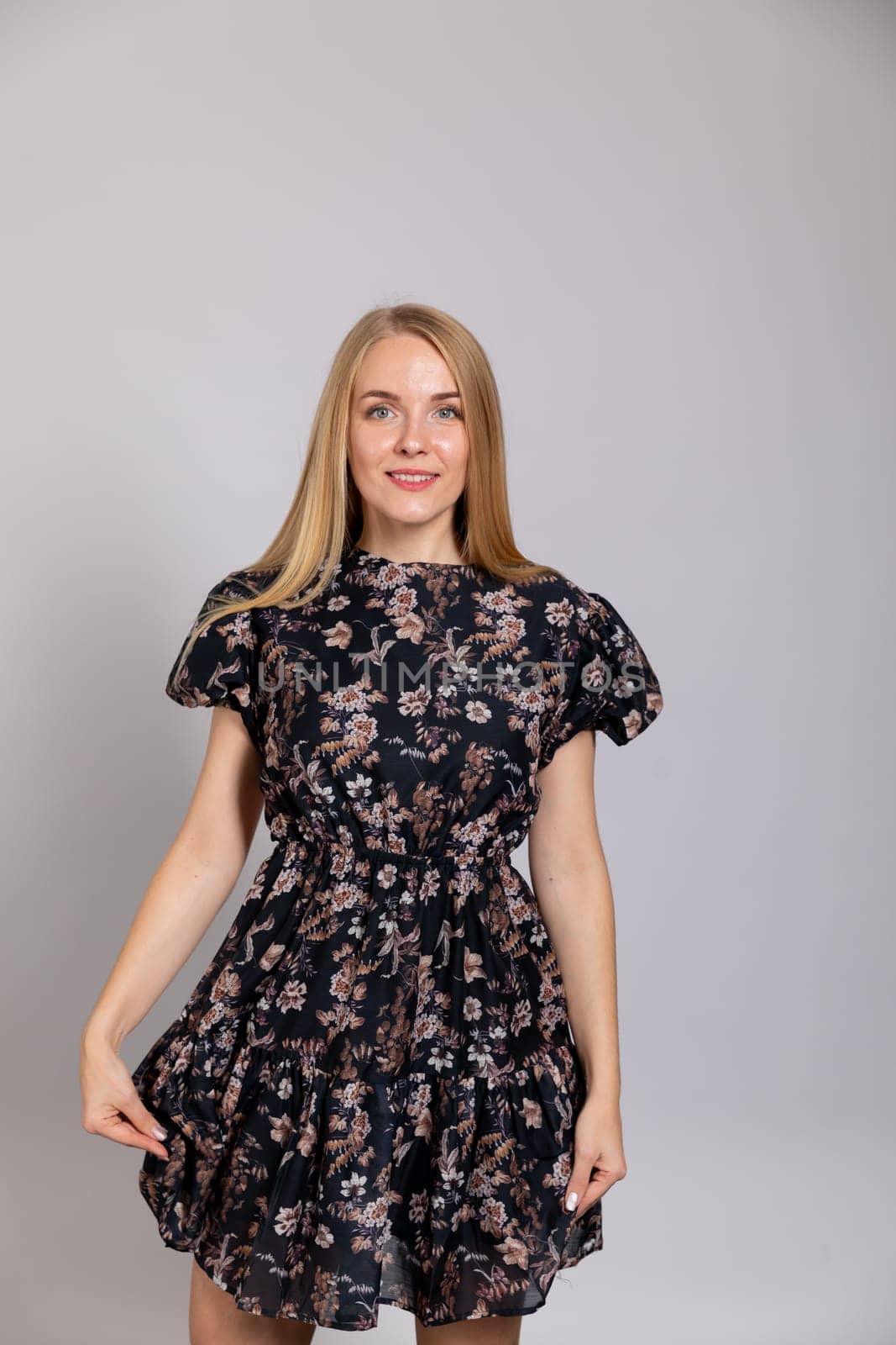 Portrait of a slender blonde woman in a dark summer dress