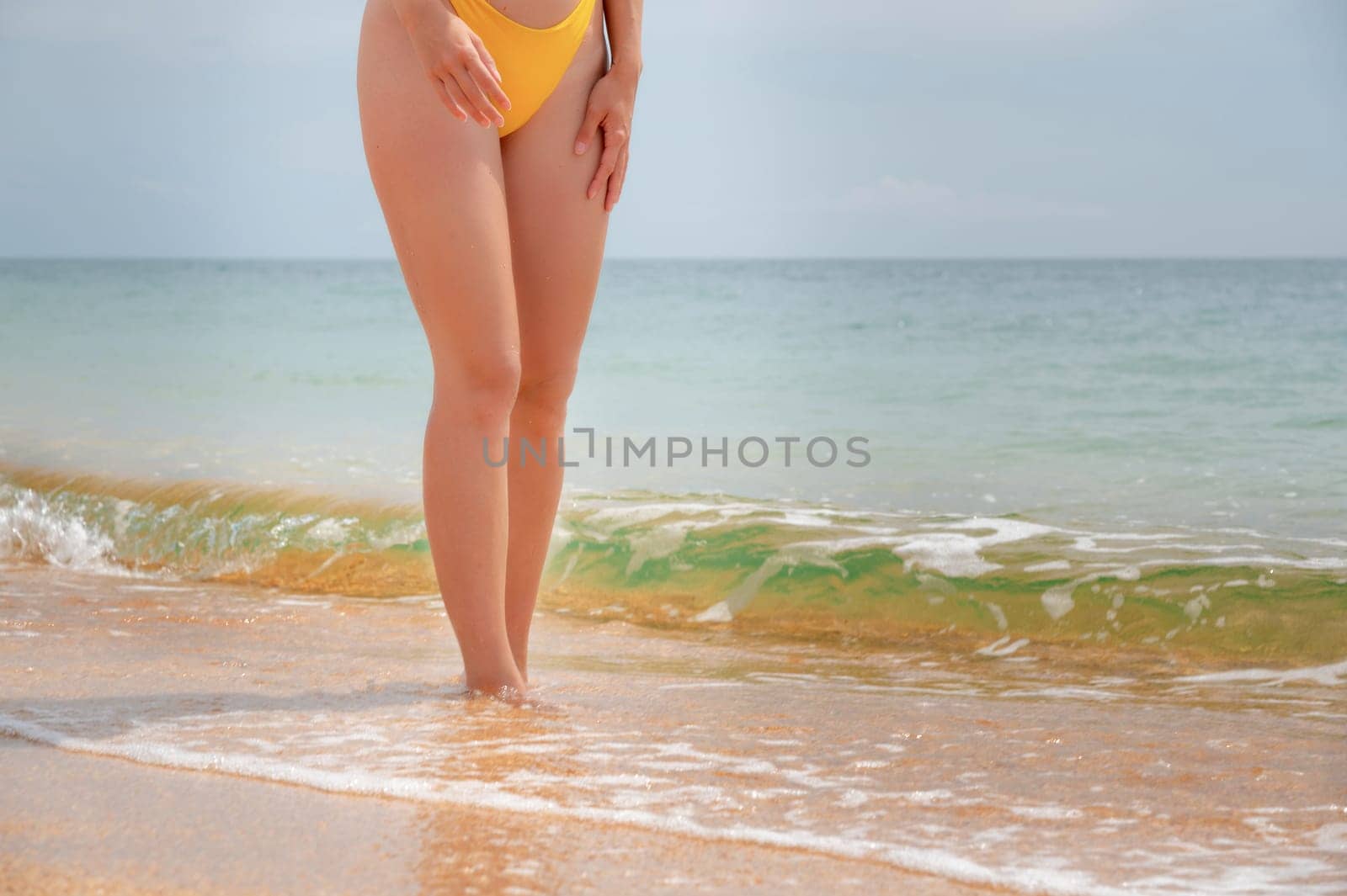 female legs stand on the seashore, sandy beach and sunshine, summer vacation idea by the ocean, sea waves. sexy female legs enjoying leisure time by yanik88