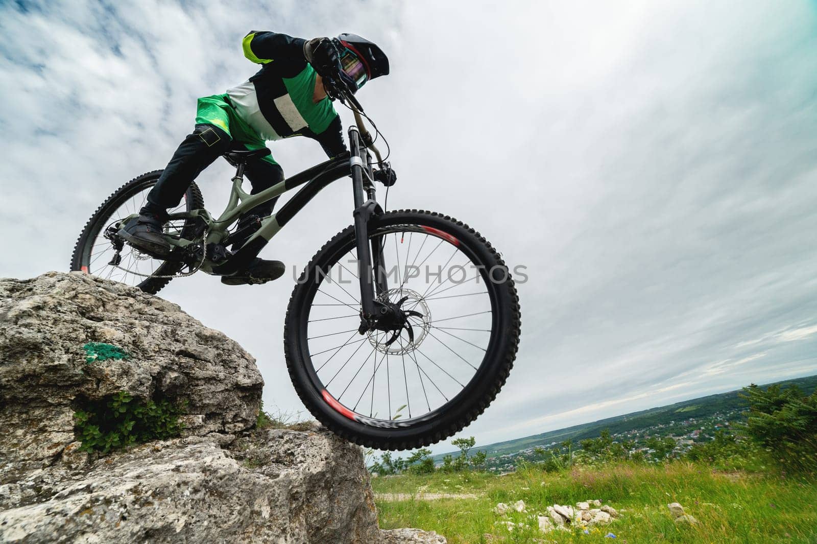 brave cyclist goes down the rocks. Test site for mountain bikers. A guy in protection rides off-road, wide angle view from below by yanik88