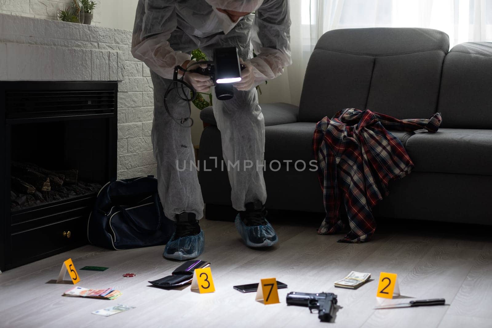 Criminological expert collecting evidence at the crime scene. High quality photo