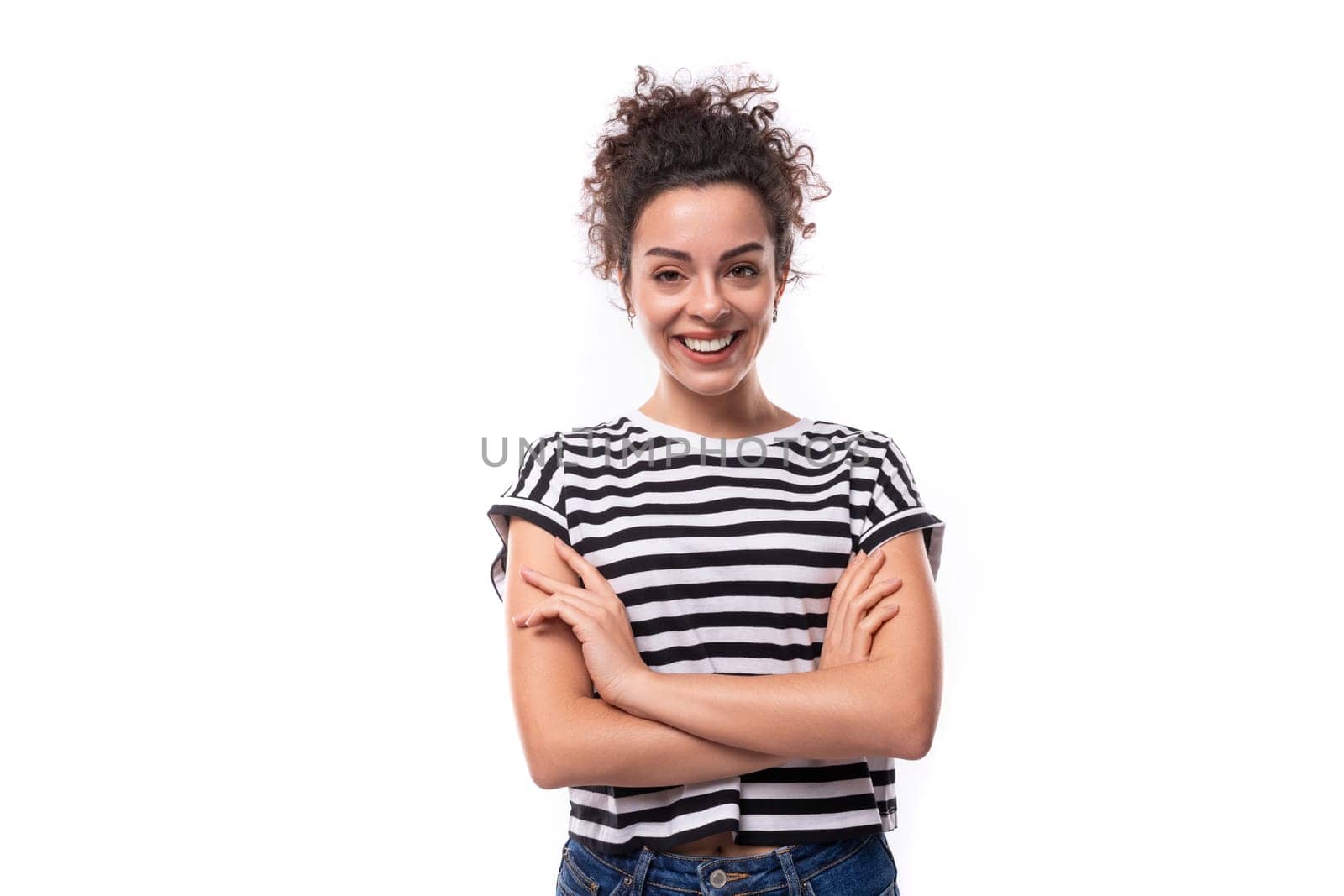 young caucasian woman with curly hair dressed in a striped summer t-shirt smiling against the background with copy space by TRMK