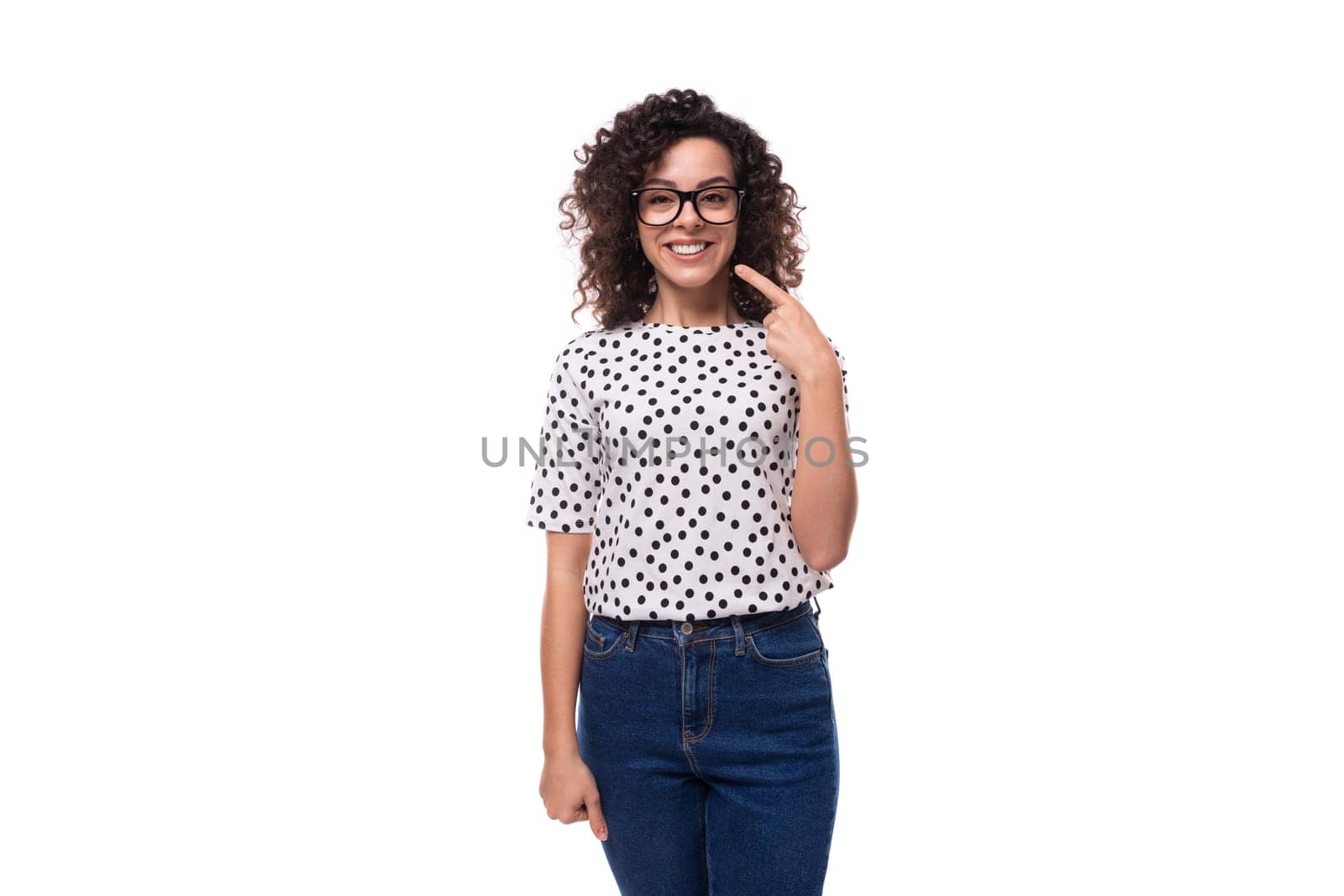 charming young brunette curly woman dressed in summer blouse with pea print smiles broadly by TRMK