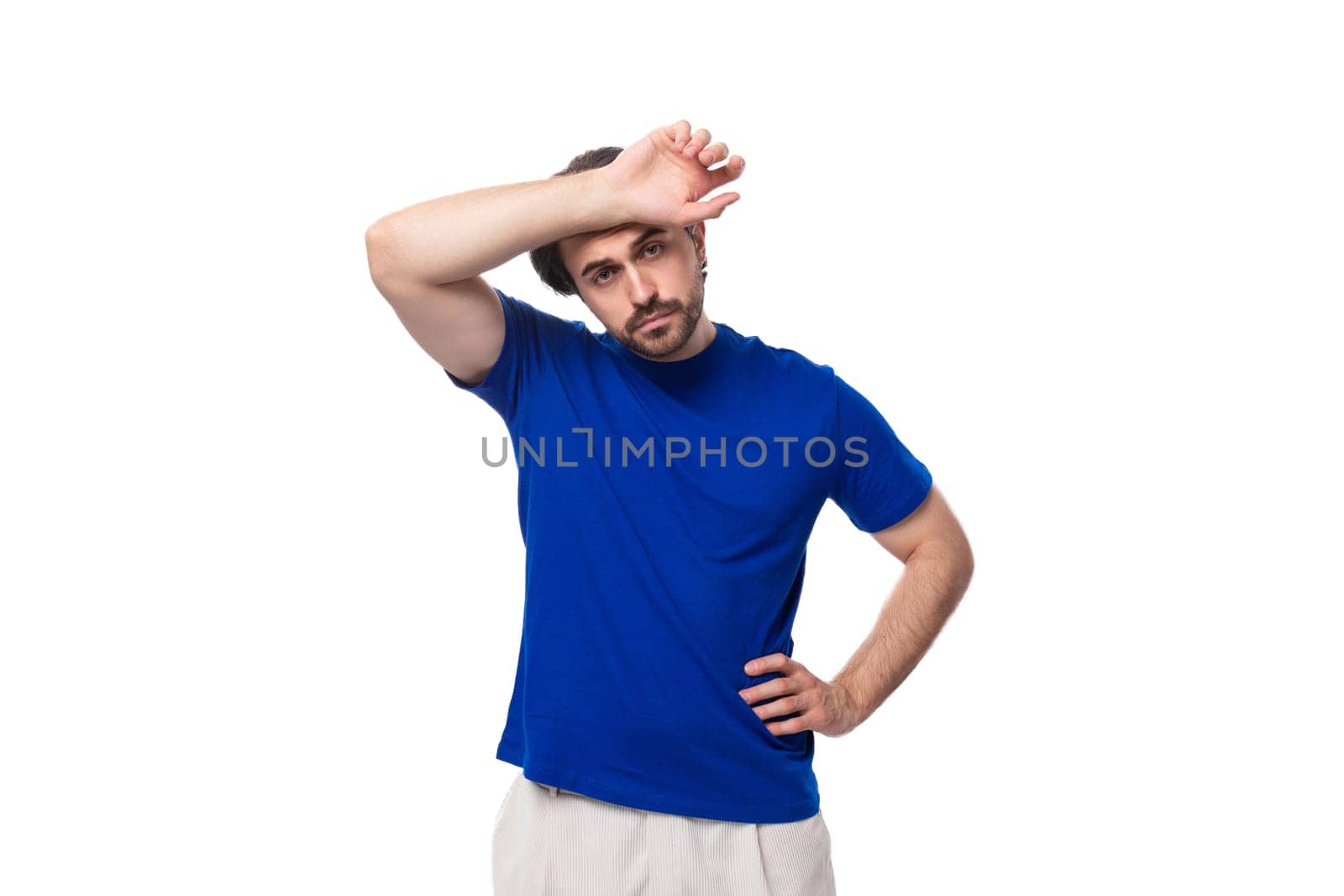 portrait of a young smart caucasian brunette man with a beard in a blue t-shirt thinking about business development. brainstorm by TRMK