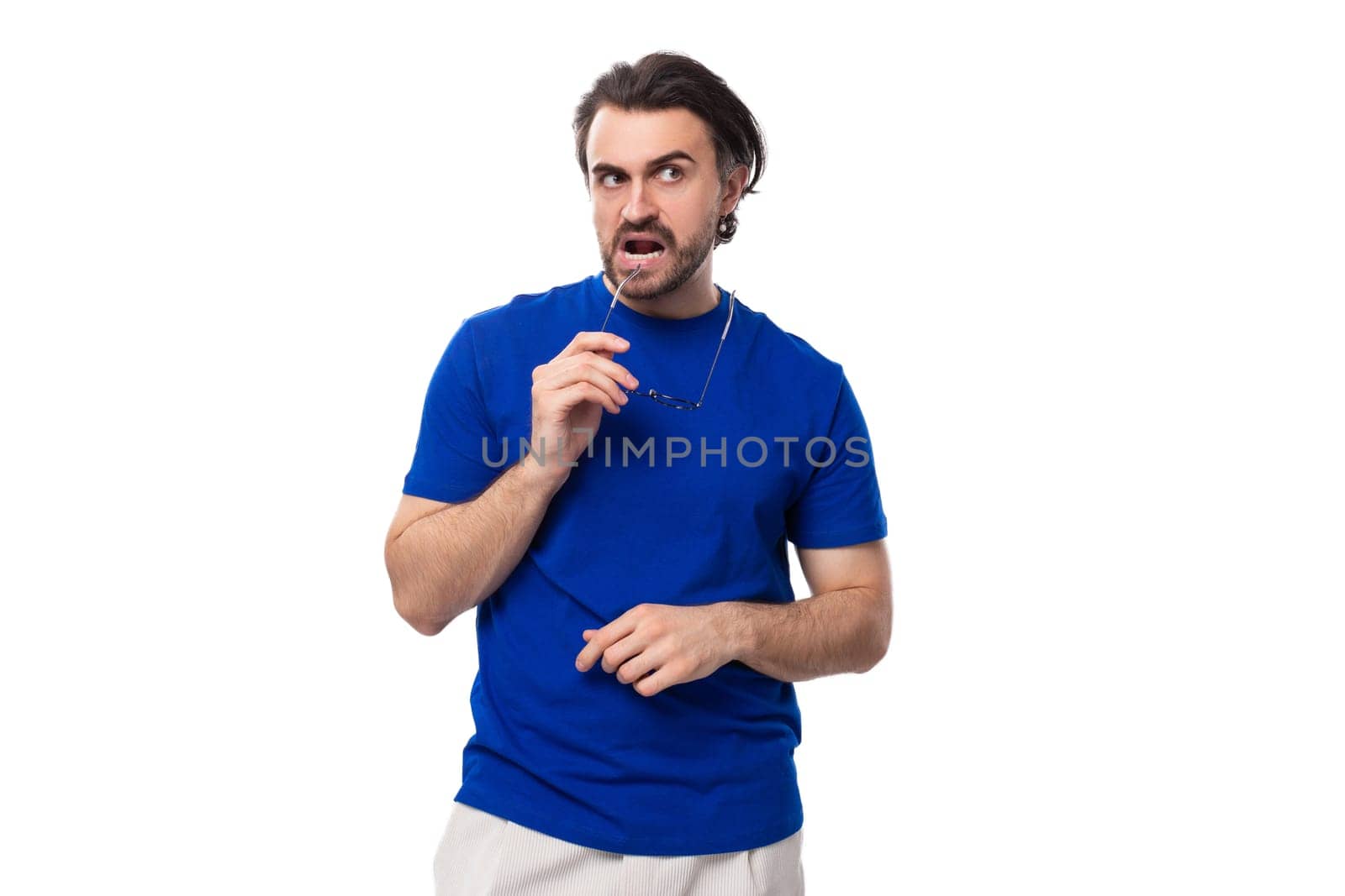 young suspicious caucasian brunette man with stylish hairstyle and beard in blue t-shirt by TRMK