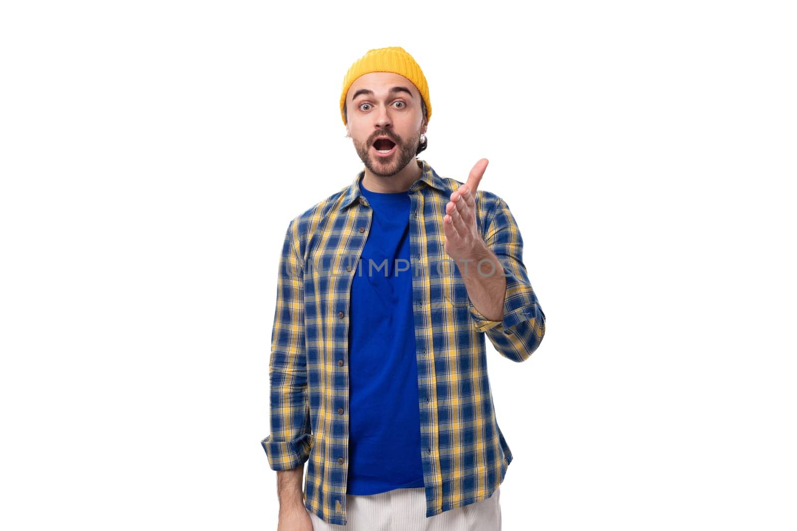 cute surprised young hipster man in yellow cap and shirt on white background with copy space by TRMK