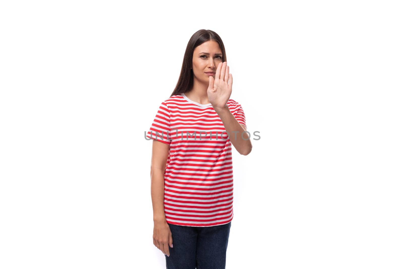 35 year old european lady in a red striped t-shirt shows a gesture of refusal and disagreement.