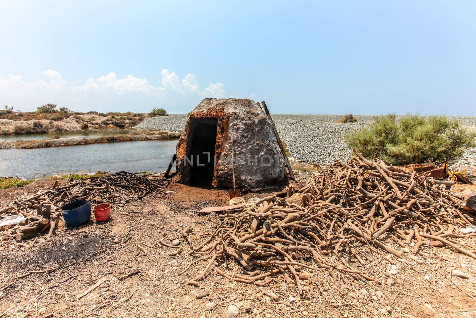 Small stone oven on the beach, used to burn tree roots for charcoal by Ivanko