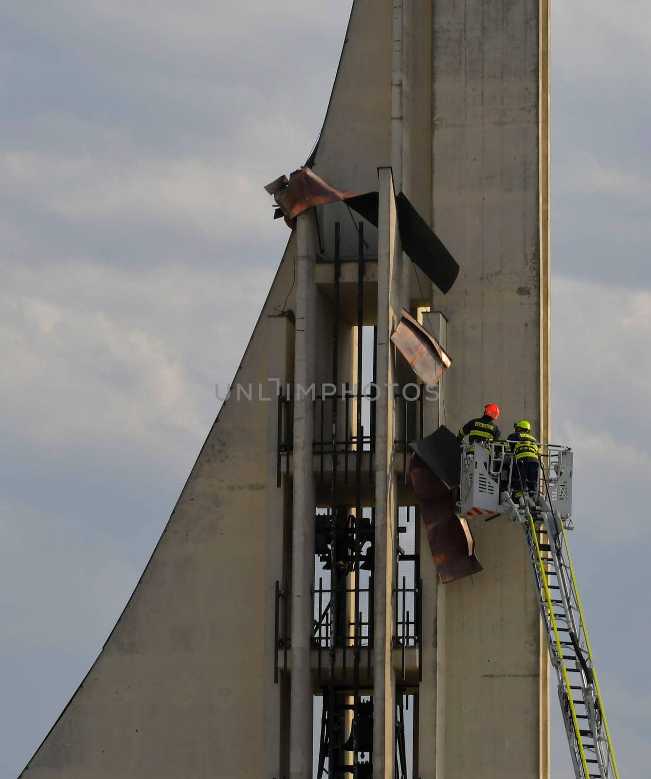 HUSTOPECE, CZECHIA - JULY 27, 2023: Firefighters at the church tower. Firefighter intervention at a high-rise building. Firefighters at the church tower. Firefighter intervention at a high-rise building. Firefighters take off metal sheets from the roof.