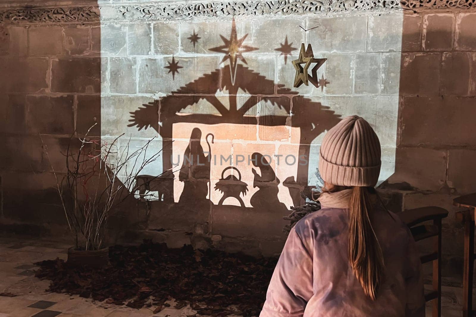 A child looks at christmas creche with Joseph Mary and small Jesus