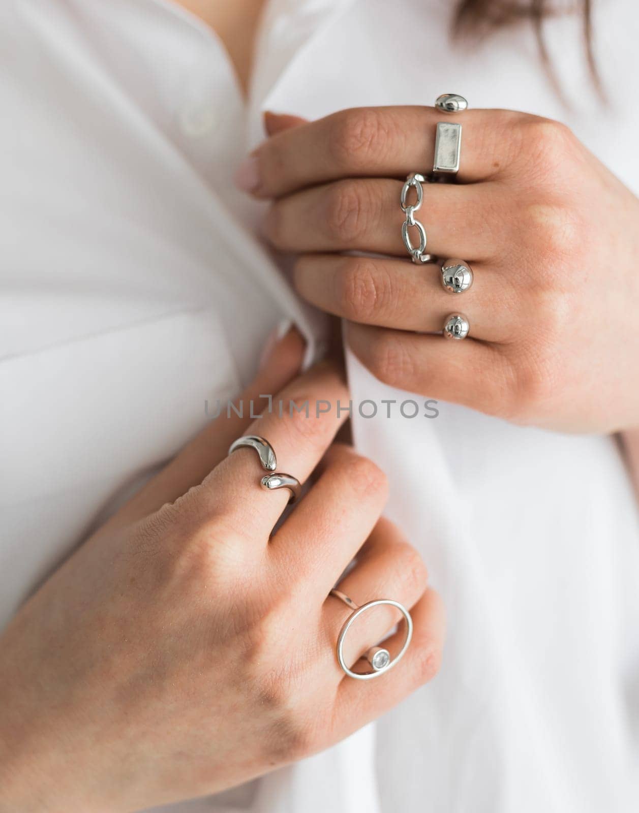 Women Jewelry concept. Woman's hands close up wearing rings and necklace modern accessories elegant lifestyle.