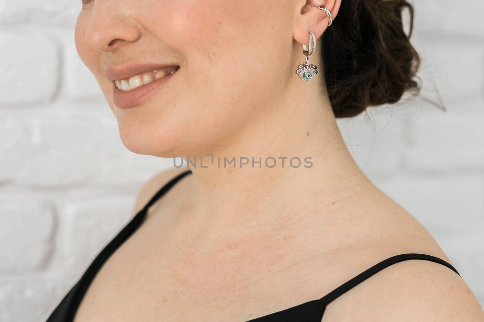 Detail of young woman wearing beautiful luxury earring. Handmade jewellery and accessories concept