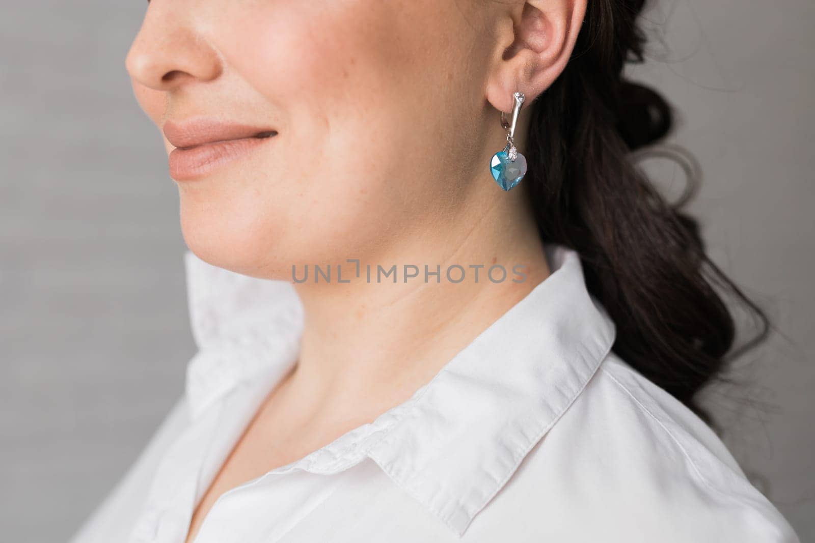 Detail of young woman wearing beautiful luxury earring. Handmade jewellery and accessories concept