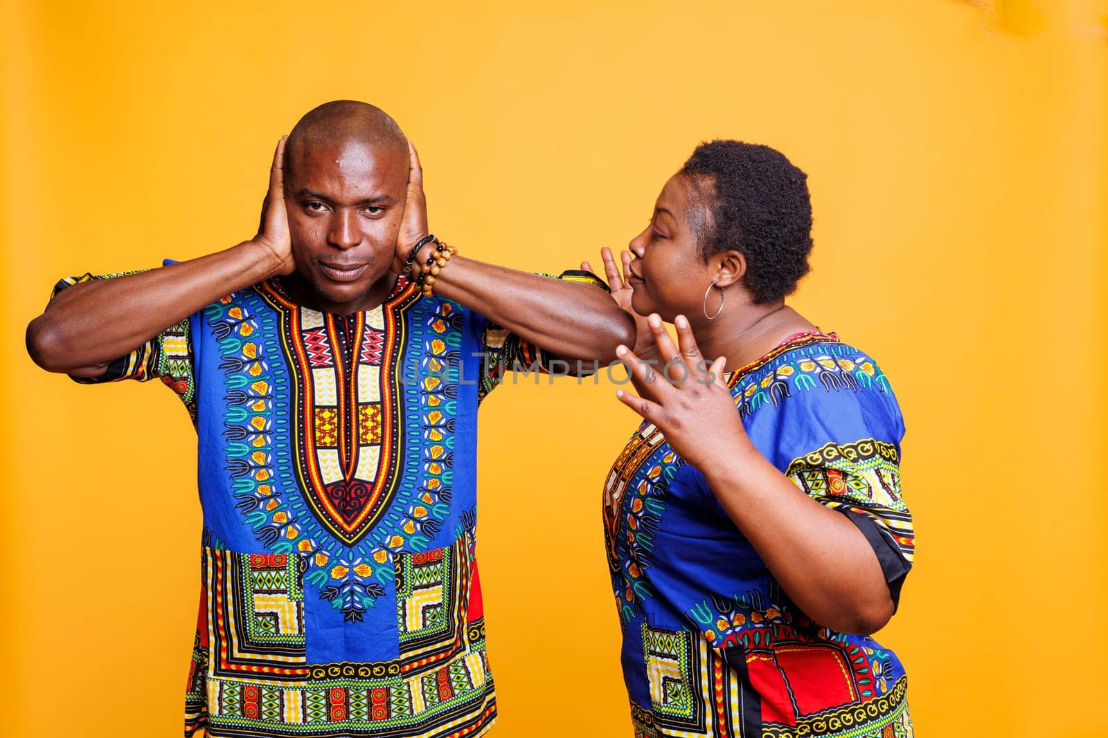 Frustrated mid adult wife getting ignored by husband during argument studio portrait. African american partners having communication misunderstanding and relationship problem