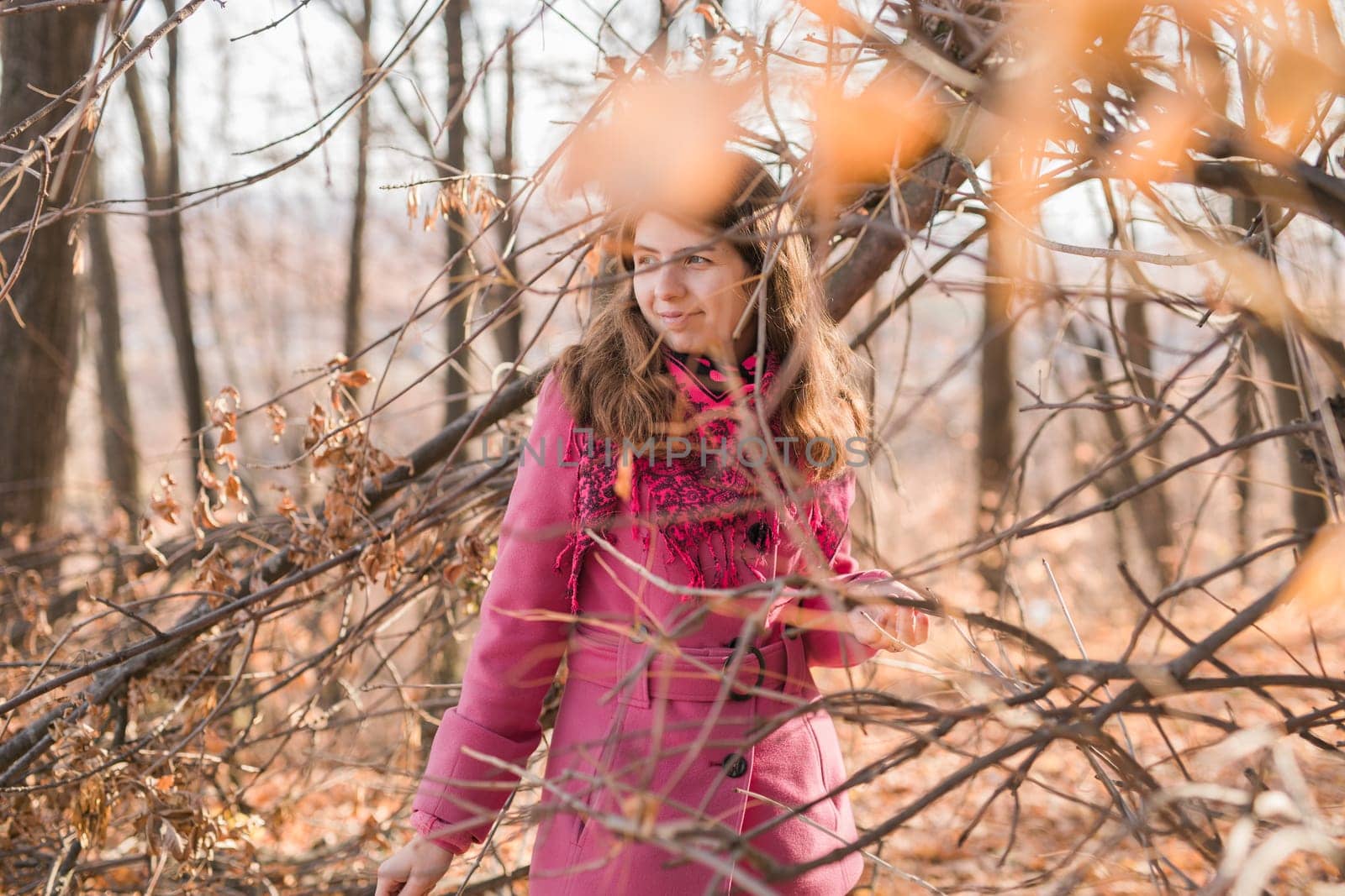 Beautiful happy smiling girl with long hair wearing black hat and pink jacket posing in autumn park. Outdoor portrait day light. Autumn mood concept. Copy empty space for text.