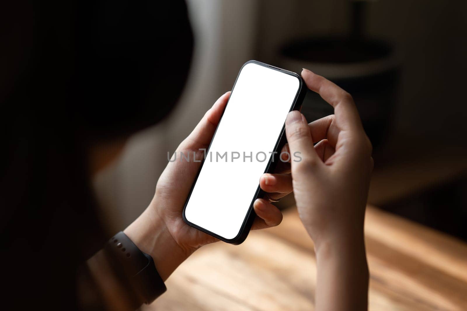 Mockup, woman's hand holding using mobile phone at coffee shop with copy space, white blank screen for text, mobile app design and advertising, online marketing by itchaznong