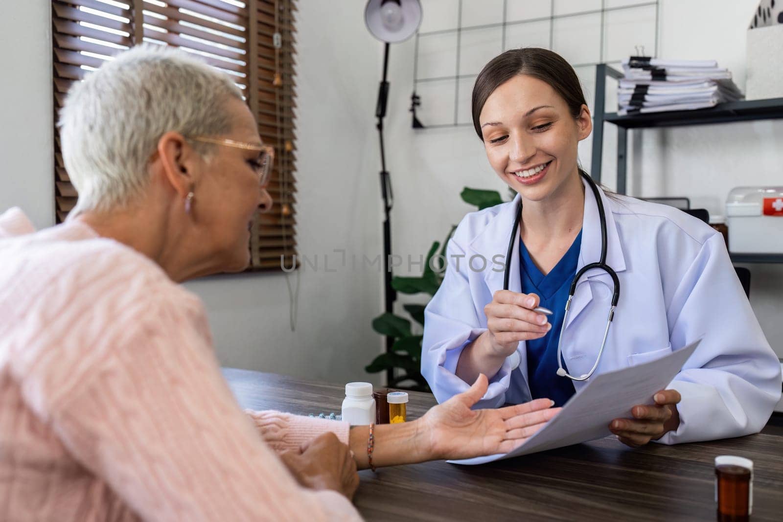 Caucasian Female doctor are advice medication and vitamin daily to caucasian elderly patient.