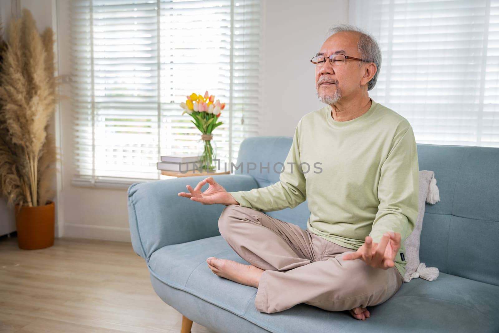 Asian old man practise yoga and meditation in lotus position and closed eyes by Sorapop
