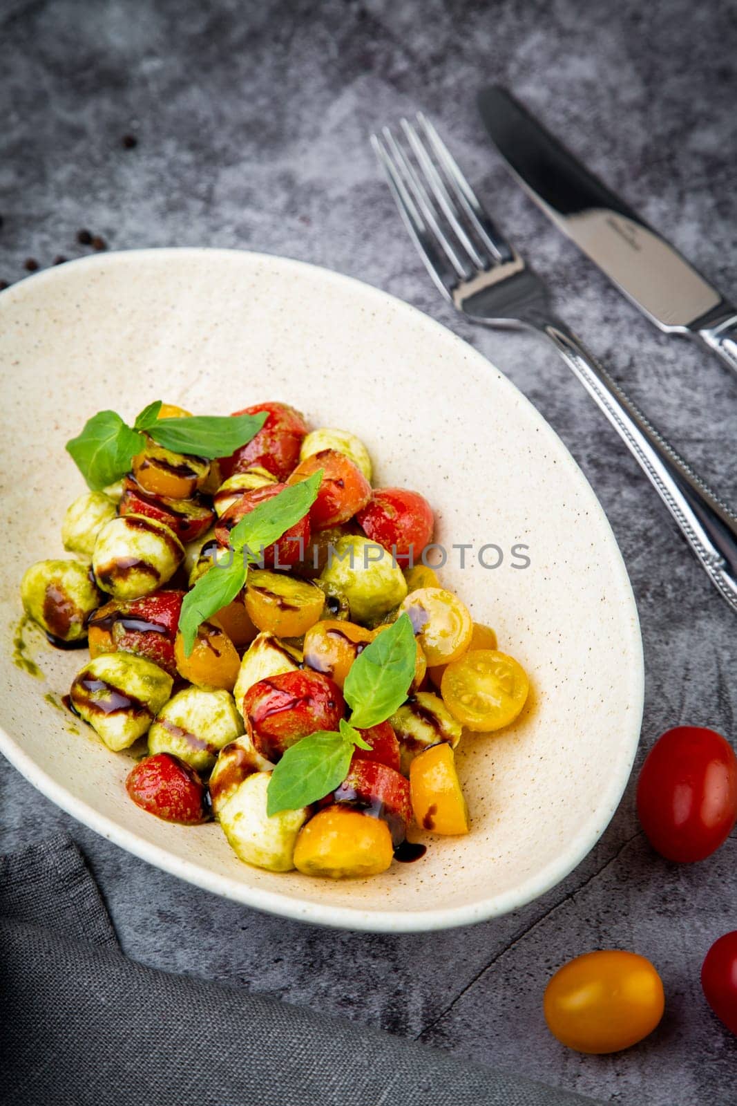 salad of yellow and red cherry tomatoes of different varieties with herbs