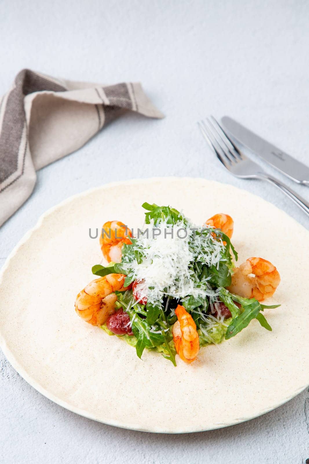 beautifully served shrimp with arugula and grated cheese