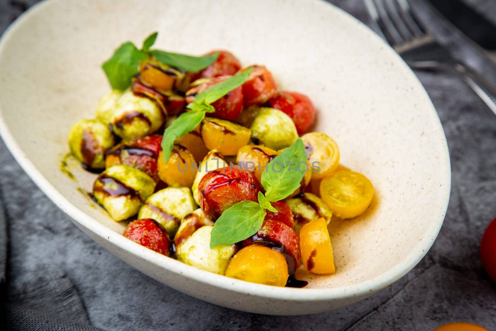 salad of yellow and red cherry tomatoes of different varieties with herbs side view by tewolf