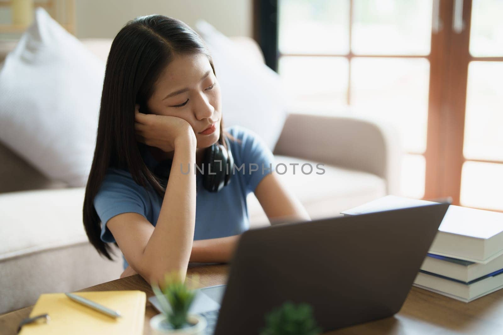Studying online, beautiful Asian female student show symptoms burnout syndrome student studying online at home.