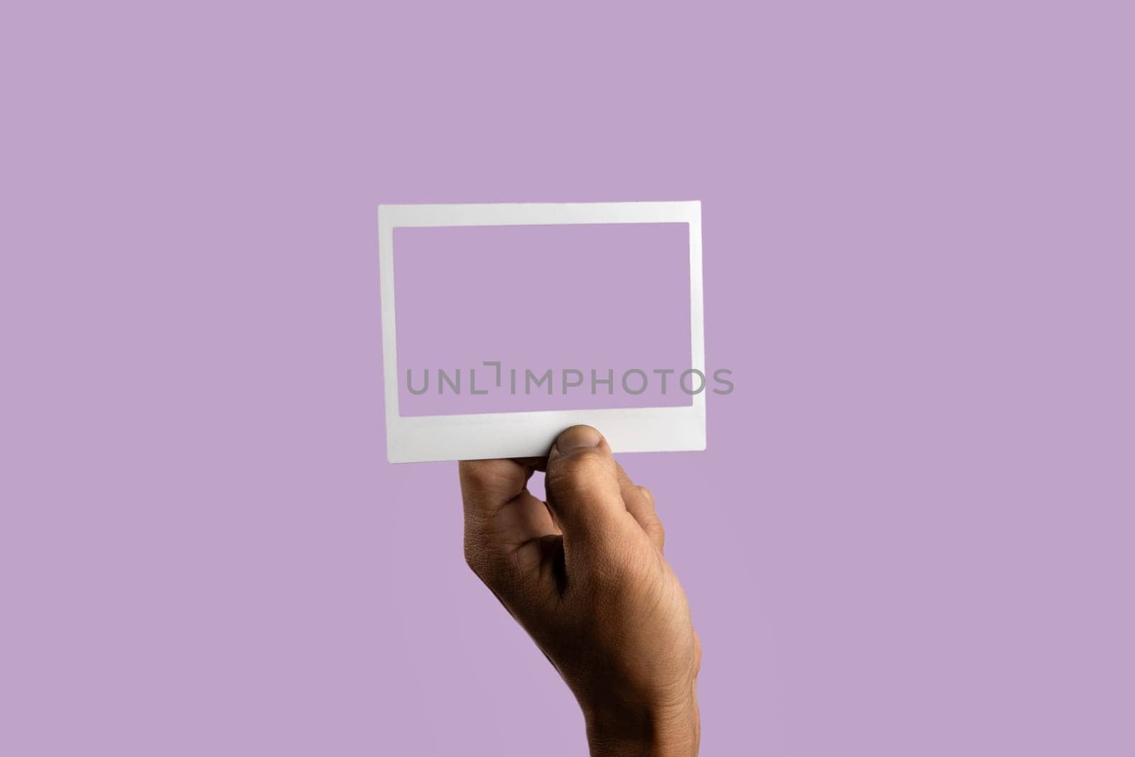 black male hand holding photo frame on isolated on light purple background by TropicalNinjaStudio