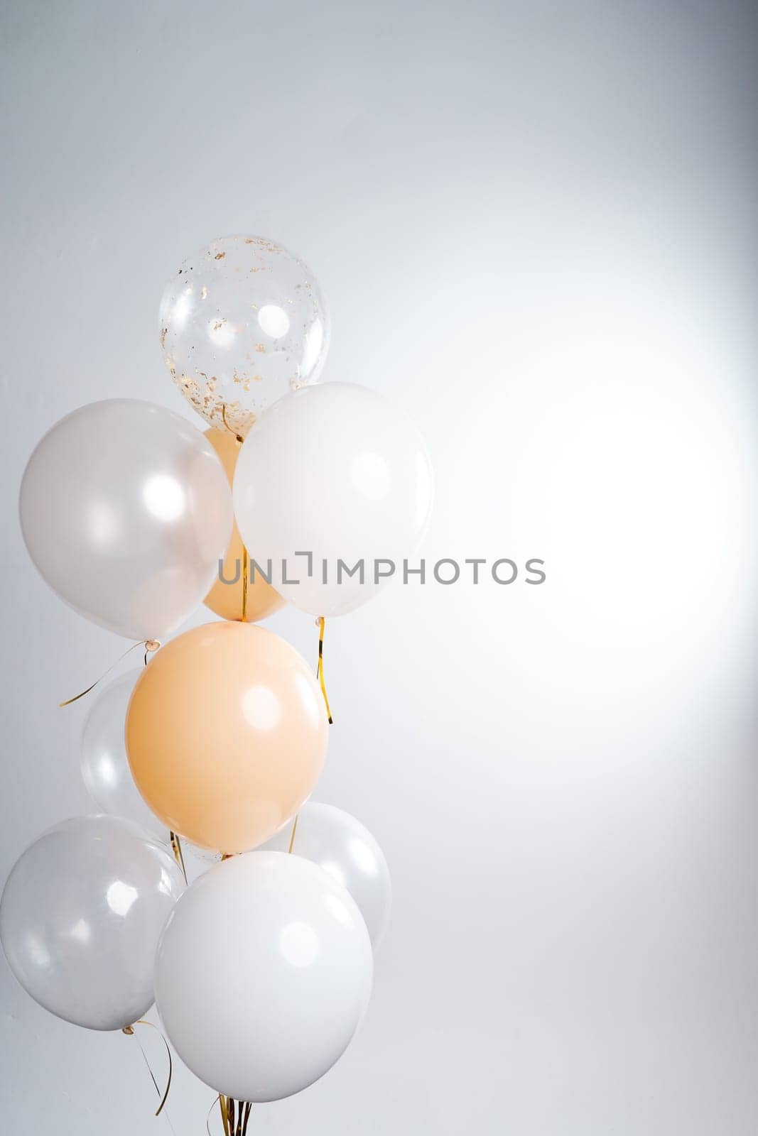 Balloons in white, beige and transparent colors on a gray background. High quality photo