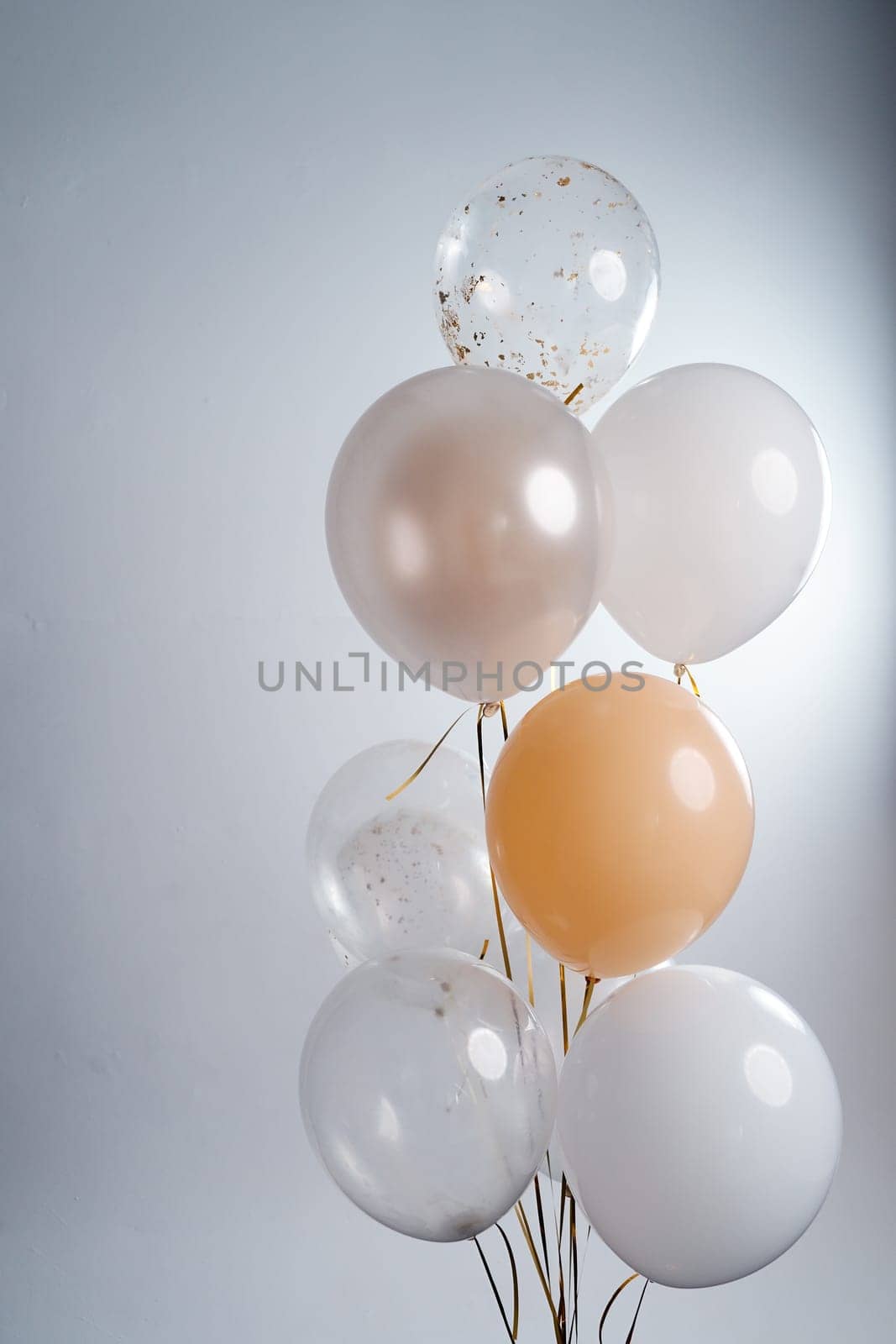 Balloons in white, beige and transparent colors on a gray background. High quality photo