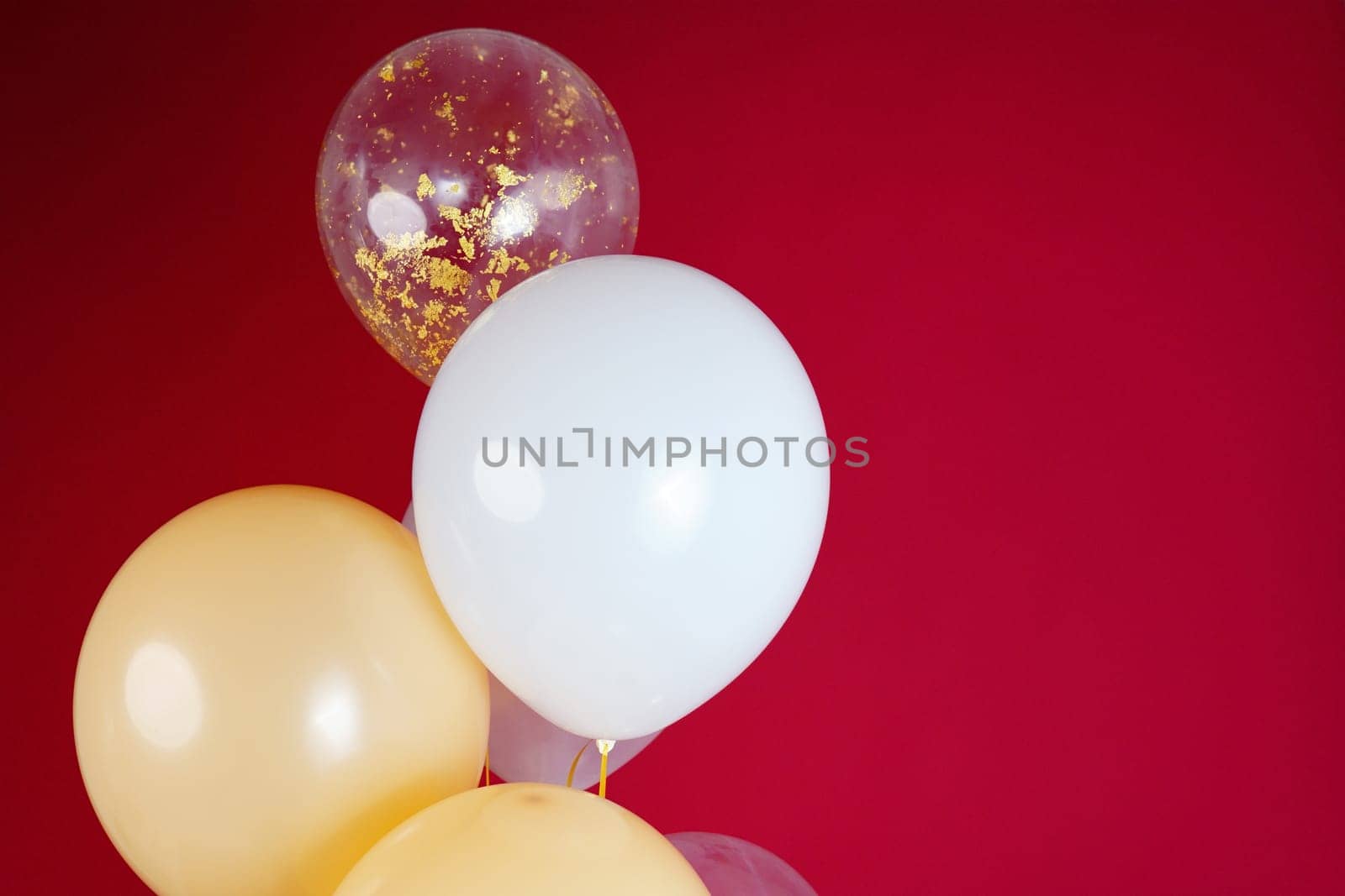 Light balloons - white, beige, transparent, pearl on a red background. Horizontal photo. Space for text by tewolf